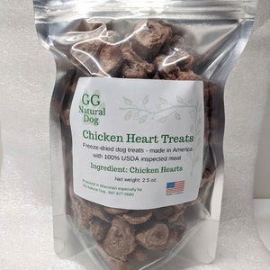 May include: A resealable bag of freeze-dried chicken heart dog treats. The bag is labeled "GG Natural Dog Chicken Heart Treats" and "Freeze-dried dog treats - made in America with 100% USDA inspected meat". The bag also states "Ingredient: Chicken Hearts" and "Net weight: 2.5 oz."