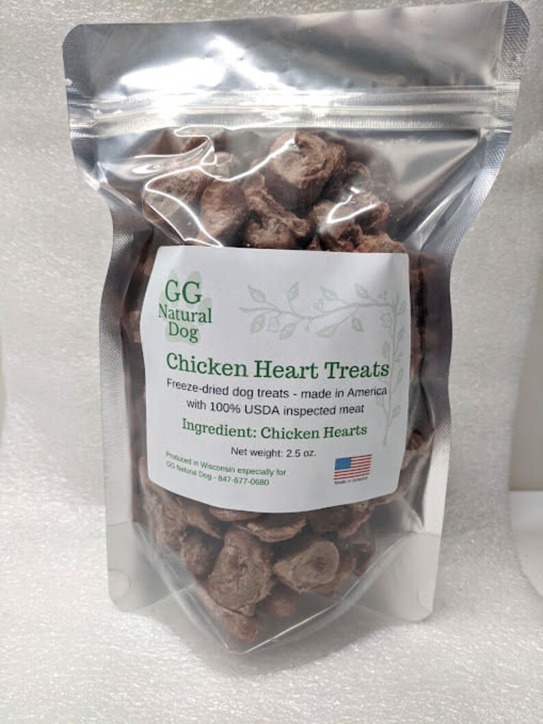 May include: A resealable bag of freeze-dried chicken heart dog treats. The bag is labeled "GG Natural Dog Chicken Heart Treats" and "Freeze-dried dog treats - made in America with 100% USDA inspected meat". The bag also states "Ingredient: Chicken Hearts" and "Net weight: 2.5 oz."