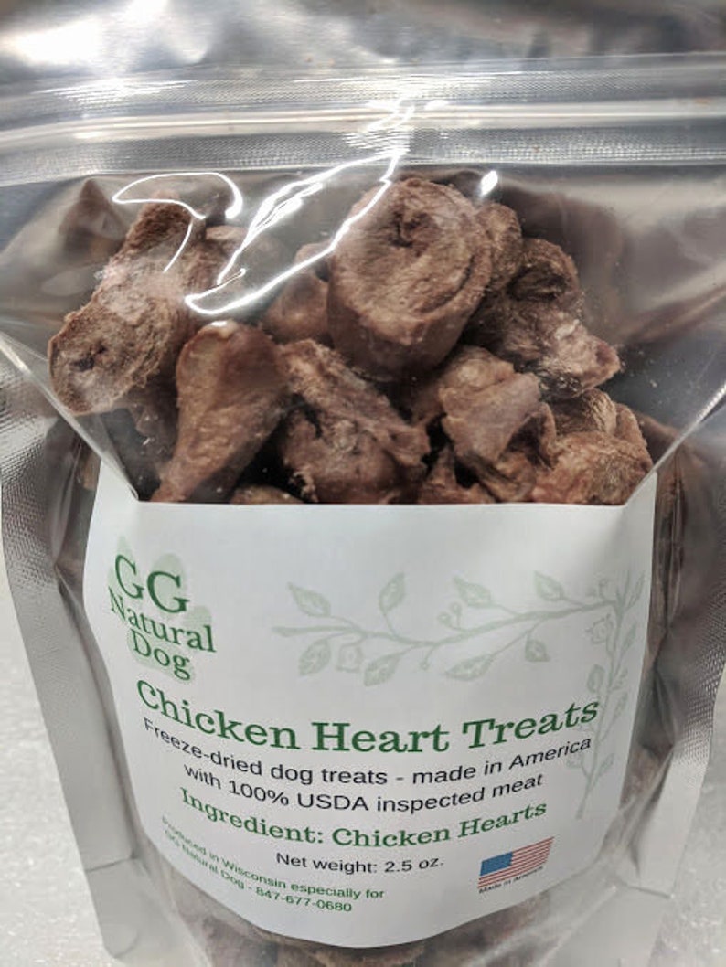 May include: A bag of freeze-dried chicken heart dog treats. The bag is white with green leaves and the text "GG Natural Dog Chicken Heart Treats" and "Freeze-dried dog treats - made in America with 100% USDA inspected meat. Ingredient: Chicken Hearts. Net weight: 2.5 oz."