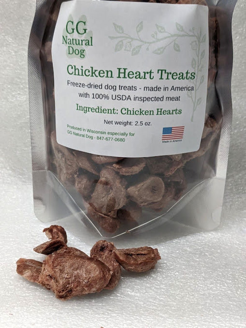 May include: A resealable bag of freeze-dried chicken heart dog treats. The bag is labeled "GG Natural Dog Chicken Heart Treats" and "Made in America". The bag contains 2.5 ounces of treats. The treats are brown and have a natural, meaty texture.