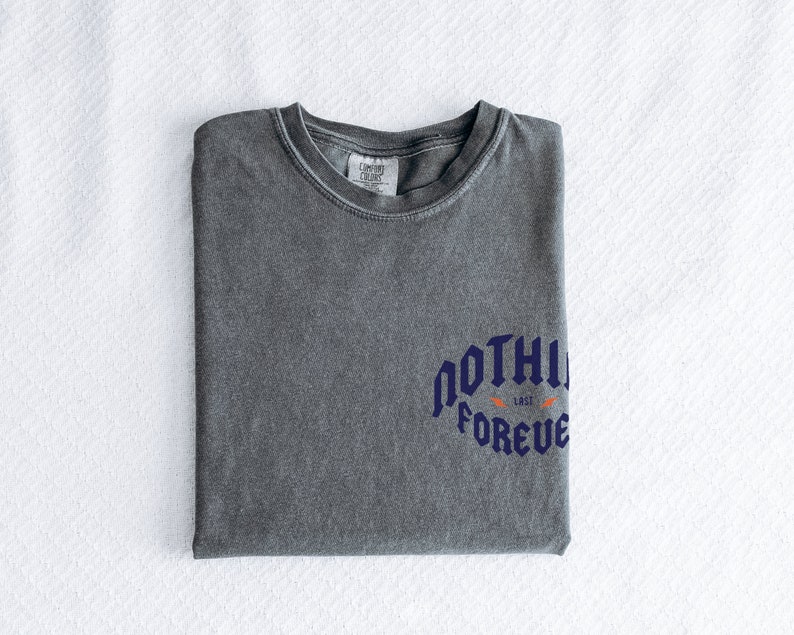 May include: A gray t-shirt with a blue graphic that says "NOTHING LASTS FOREVER" with a small orange graphic above the text.