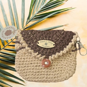 Um pingente de bolsa que também funciona como uma minibolsa para guardar fones de ouvido ou moedas. Um chaveiro para sua bolsa favorita com um toque de estilo de crochê feito à mão.