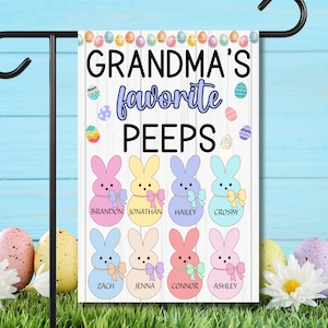 May include: A garden flag featuring the text "GRANDMA'S favourite PEEPS" and bunny illustrations. Each bunny is a different colour and has a name underneath. Easter eggs decorate the top of the flag.
