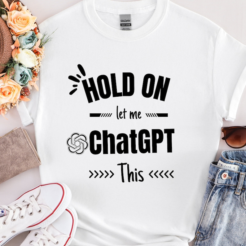 May include: White t-shirt with black text that reads "Hold on let me ChatGPT This" with arrows pointing to the text.