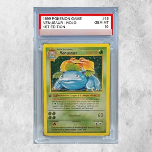 Può includere: Una carta collezionabile Venusaur Holo del 1999, 1ª edizione, classificata GEM MT 10, racchiusa in una custodia protettiva in plastica trasparente. La carta raffigura il personaggio blu Venusaur con un grande fiore sulla schiena, 100 HP e l'attacco Solarbeam.
