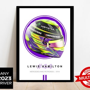 Puede incluir: Un p&oacute;ster enmarcado que presenta un primer plano de un casco de carreras de F&oacute;rmula 1 con un dise&ntilde;o morado, verde y negro. El casco tiene las palabras "Monster Energy", "Crowdstrike" y "Akkodis" en &eacute;l. El p&oacute;ster tambi&eacute;n incluye el texto "Lewis Hamilton #44 Mercedes AMG Petronas | W14".