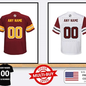 Puede incluir: Dos camisetas de fútbol personalizables, una roja y otra blanca, con el texto "ANY NAME" y "00" en la espalda. Las camisetas se muestran sobre un fondo blanco con un estante de madera debajo. Una oferta de compra múltiple se muestra en la esquina inferior izquierda. Una pequeña bandera estadounidense se muestra en la esquina inferior derecha con el texto "U.S. & WORLDWIDE FREE SHIPPING CODE: DIGITAL (Digital prints only)".