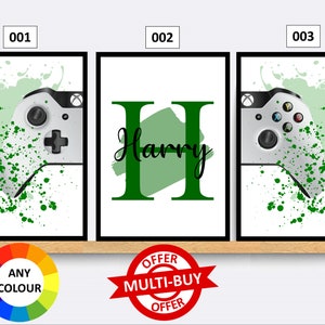 May include: Three framed prints with a green and white colour scheme. The first and third prints feature a white video game controller with green splatters. The middle print features the name "Harry" in green letters with a green brushstroke behind it.