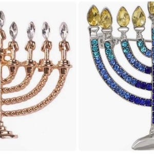 May include: Two decorative menorahs. One is gold-toned with clear crystal-like accents. The other is silver-toned with blue and yellow jewel-like accents. Both have nine candle holders and are designed for the Jewish holiday of Hanukkah.