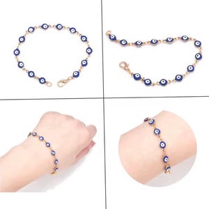 Könnte beinhalten: Goldfarbenes Armband mit blauen und weißen Evil-Eye-Anhängern. Das Armband hat eine filigrane Kette und einen Karabinerverschluss. Die Evil-Eye-Anhänger sind gleichmäßig auf der Kette verteilt.