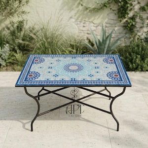 May include: Rectangular outdoor coffee table with a mosaic tile top. The tile features a blue, white, and red geometric pattern. The table has a dark metal frame and the text "APT LAVARDE" is visible.