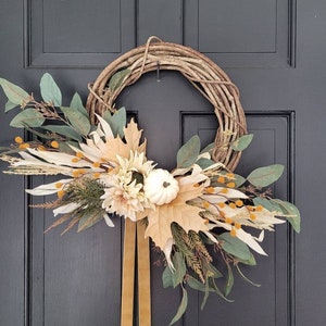 Neutral fall wreath with corn husks, cream sunflower, white pumpkin, and beige maple leaves for your fall decor and front door or porch