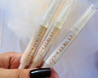 May include: Three clear plastic tubes with white liquid inside. The tubes have a brown label with the word "GLOWIE" printed on them.