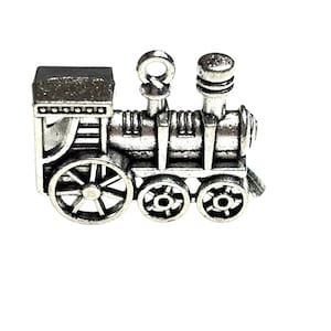 May include: A silver-toned metal train charm with a detailed design. The train has a rounded top, a chimney, and three wheels.