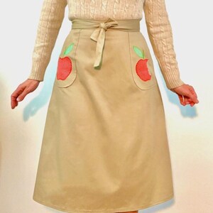 Adorable 70’s khaki wrap skirt with apple appliqués and patch pockets