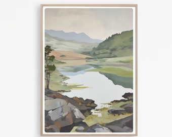 May include: A framed landscape painting depicts a serene lake scene. The artwork features a light brown wooden frame. The painting showcases a lake surrounded by green hills, mountains, and a cloudy sky. Large gray rocks are in the foreground.