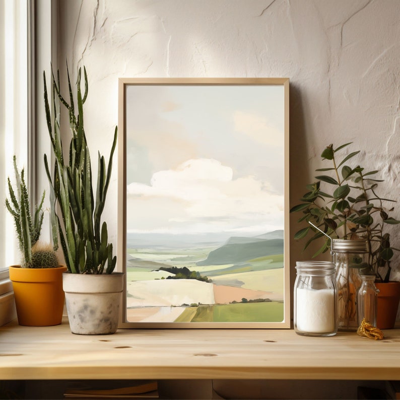 Puede incluir: Una pintura abstracta de paisaje enmarcada con un cielo azul claro, nubes blancas y colinas verdes. La pintura est&aacute; en un marco de madera y est&aacute; colgada en una pared.