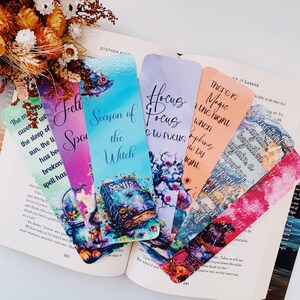 K&ouml;nnte beinhalten: Satz von sechs bunten Lesezeichen mit einem Hexenthema. Jedes Lesezeichen hat ein anderes Design mit Aquarell-Illustrationen und Text. Der Text beinhaltet "Season of the Witch", "Spells", "Hocus Focus", "There is Magic in the Night", "Bewitched Again" und "Spellbound".