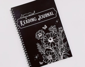 May include: Black spiral bound journal with the text "Reading Journal" in white lettering. The cover features a white silhouette of a cat, flowers, and butterflies.