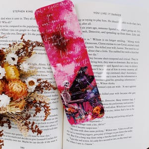 K&ouml;nnte beinhalten: Ein pink- und lilafarbenes Lesezeichen mit einem Skelett, das Klavier spielt. Das Lesezeichen enth&auml;lt den Text "When the sun goes down the fun comes up" und "I can't stop at things I ain't lyin".