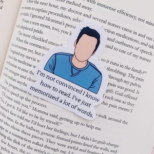 May include: A sticker with a cartoon illustration of a person with blue hair and a blue shirt. The sticker has the text "I'm not convinced I know how to read. I've just memorized a lot of words."