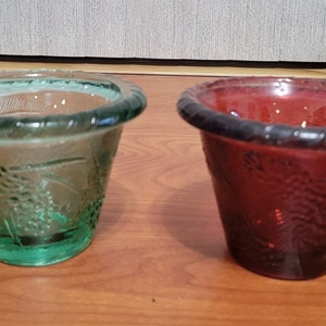 May include: Two small glass candle holders, one green and one red, with a textured design.