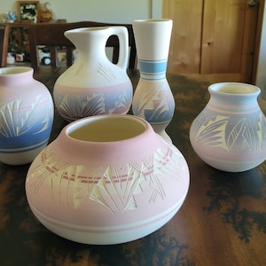 Peut inclure: Cinq vases en céramique avec des motifs d'inspiration sud-ouest. Les vases sont dans des tons de rose, bleu et blanc avec des motifs complexes.