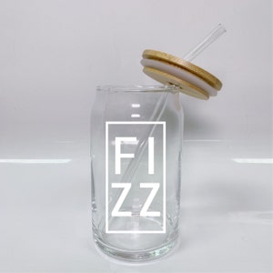 Pode incluir: Uma lata de vidro transparente com um gráfico branco de "FIZZ" e uma tampa de bambu com um canudo de vidro transparente.