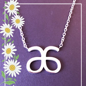 May include: A silver necklace with a simple infinity symbol pendant. The necklace is on a purple background.