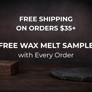 May include: Dark brown background with white text that reads "FREE SHIPPING ON ORDERS $35+" and "FREE WAX MELT SAMPLE with Every Order." A small, dark brown rectangular block and a dark gray, oval-shaped stone are in the foreground.