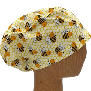 May include: A yellow and black scrub hat with a honeycomb pattern and cartoon bees.