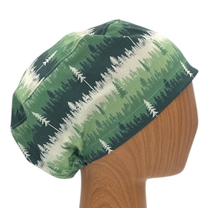 May include: Green and white scrub hat with a forest print. The hat has a tie on the back.