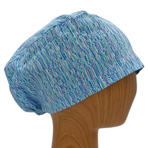 May include: A blue and white patterned surgical scrub hat with a light blue and white abstract design.