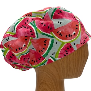 May include: A pink and green scrub hat with a watermelon print. The hat is made of a soft, comfortable fabric and is perfect for nurses, doctors, and other healthcare professionals.