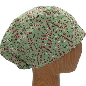 May include: Green scrub hat with a red and white candy cane pattern.