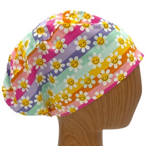 May include: A colorful surgical scrub hat with a rainbow stripe pattern and yellow smiley faces. The hat is made of a soft, comfortable fabric and is perfect for nurses, doctors, and other healthcare professionals.
