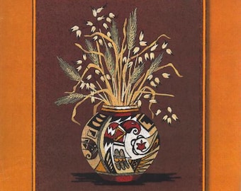 May include: A Sunset Stitchery embroidery kit featuring an Indian Heritage design. The image shows a vase with wheat stalks, in a brown and orange color scheme. The kit fits a 16" x 20" frame.