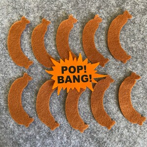 May include: Ten brown felt sausage shapes with the words "POP! BANG!" in a yellow starburst shape.