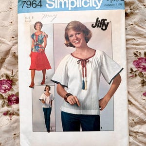 May include: Vintage Simplicity sewing pattern, size 8 Miss, featuring a Jiffy top and skirt. The pattern cover shows a woman wearing a white top with a red trim and a skirt. The cover has the text "Simplicity" and "Jiffy".