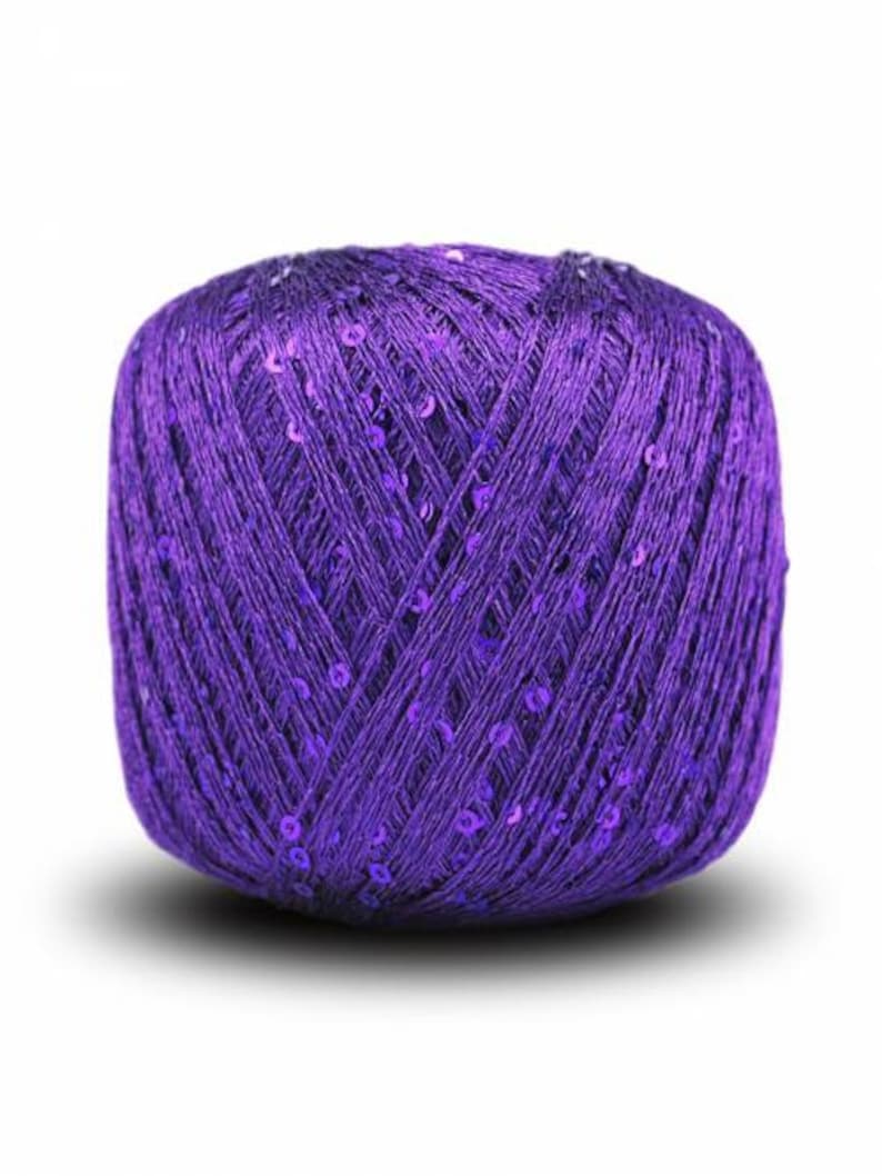 Pu&ograve; includere: Un gomitolo di filato viola con paillettes intrecciate nel filato.