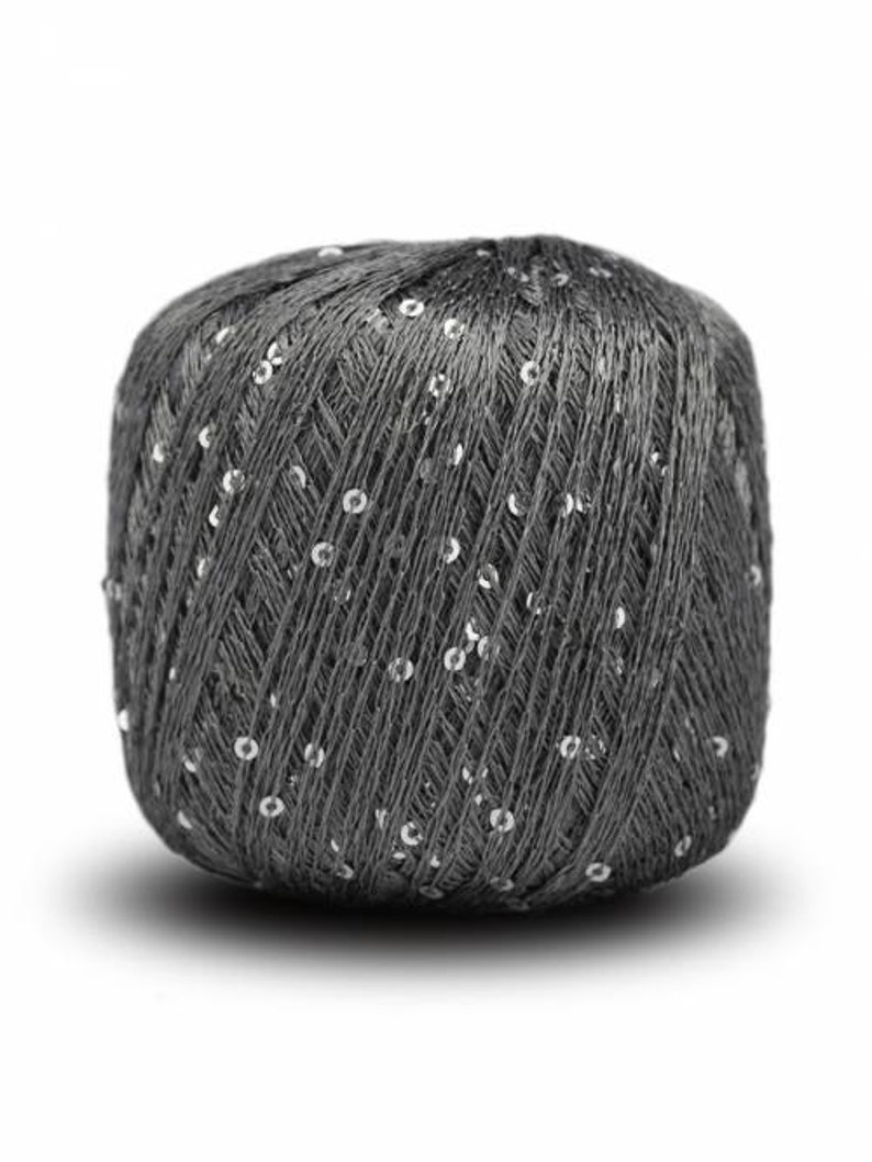 Puede incluir: Ovillo de hilo gris oscuro con lentejuelas plateadas incrustadas. El hilo est&aacute; bien enrollado y las lentejuelas est&aacute;n espaciadas uniformemente en la superficie, agregando un toque de brillo. Ideal para proyectos de tejido y ganchillo.