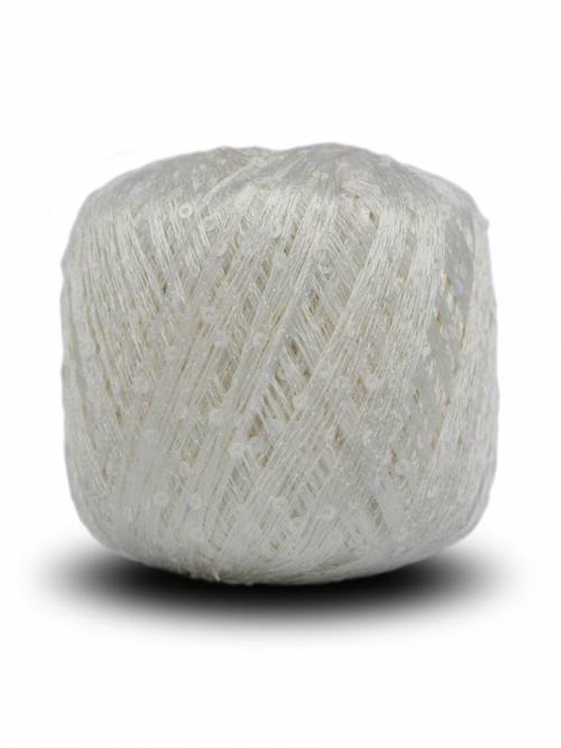 Puede incluir: Una madeja de hilo blanco, bien enrollada con una superficie texturizada. El hilo parece tener un ligero brillo, lo que sugiere una mezcla de materiales. Ideal para tejer, hacer ganchillo u otras manualidades.