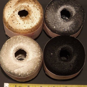 Puede incluir: Cuatro carretes de hilo decorativo en oro, plata, negro y gris oscuro. Cada carrete tiene forma de rosquilla con un agujero central y est&aacute; envuelto en una etiqueta de papel. El hilo parece tener una textura con lentejuelas o brillante.