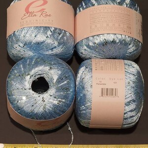 May include: Four balls of blue yarn with silver sequins. The yarn is labelled "Ella Rue Sequinicity" and "Color 12 Periwinkle, Dye Lot 101".