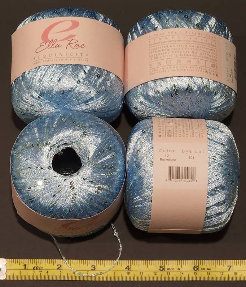 May include: Four balls of blue yarn with silver sequins. The yarn is labelled "Ella Rue Sequinicity" and "Color 12 Periwinkle, Dye Lot 101".