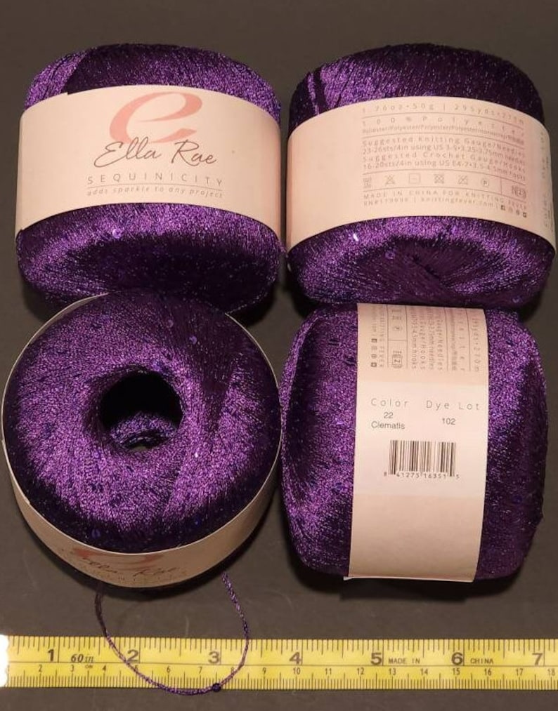 Pu&ograve; includere: Quattro rocchetti di filo viola con paillettes. Il filo &egrave; etichettato "Ella Rae Sequinicity add sparkle to any projects". L'etichetta include anche il colore "Clematis" e il numero di lotto di tintura 102.
