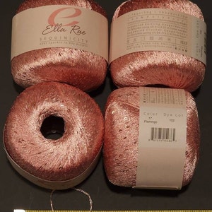Pu&ograve; includere: Quattro rocchetti di filo rosa con paillettes, etichettati "Ella Rue Sequinicity adds sparkle to any project". Il filo &egrave; etichettato "Color 17 Flamingo, Dye Lot 102".
