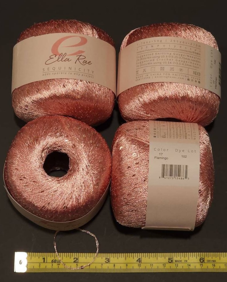 Pu&ograve; includere: Quattro rocchetti di filo rosa con paillettes, etichettati "Ella Rue Sequinicity adds sparkle to any project". Il filo &egrave; etichettato "Color 17 Flamingo, Dye Lot 102".