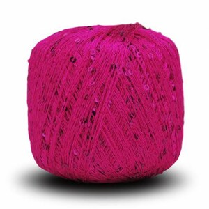 Pu&ograve; includere: Un gomitolo di filato rosa brillante con paillettes intrecciate.