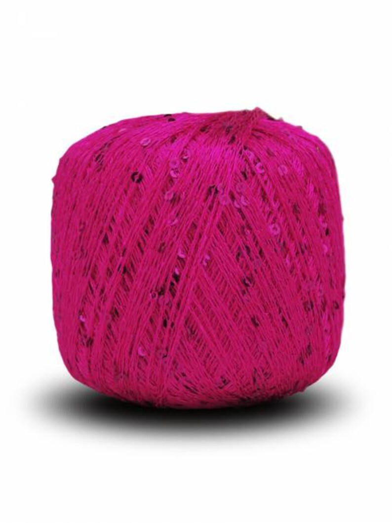 Pu&ograve; includere: Un gomitolo di filato rosa brillante con paillettes intrecciate.